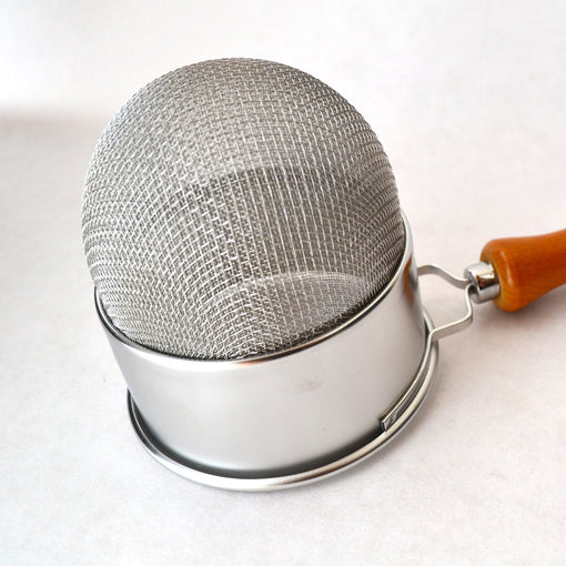 deep basket strainer with wood handle This stainless steel strainer with wood handle features a double mesh strain, for jobs that require fine pieces of ice, tea or herbs to be strained. The deep basket design enables enough room for ice cubes, large herbs or leaves. The wood handle is not only handsome, but also provides a weightiness that provides stability and good feel in the hands